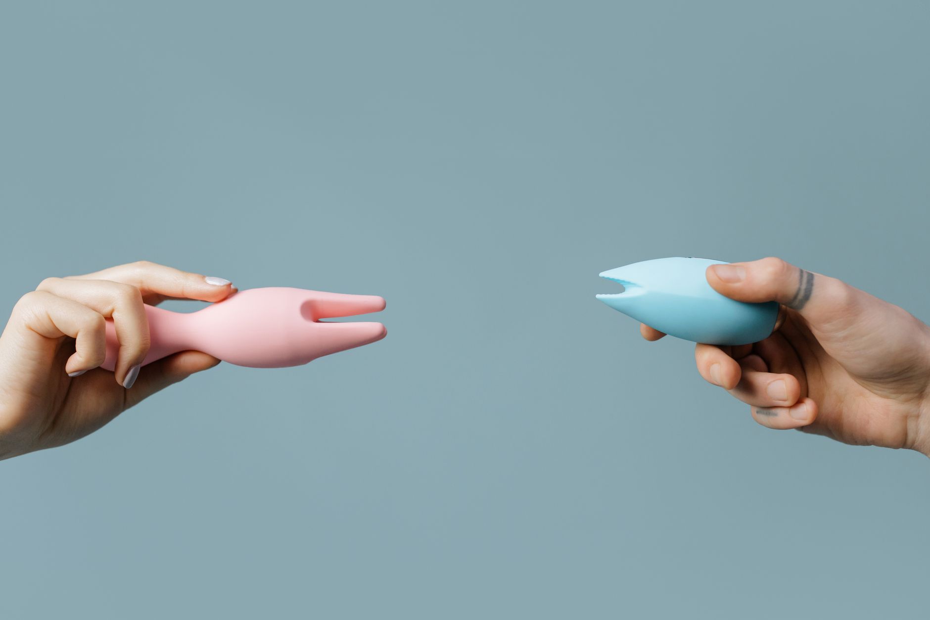 A hand holding a fresh lemon against a vivid yellow background, symbolizing the lemon vibrator's bright energy