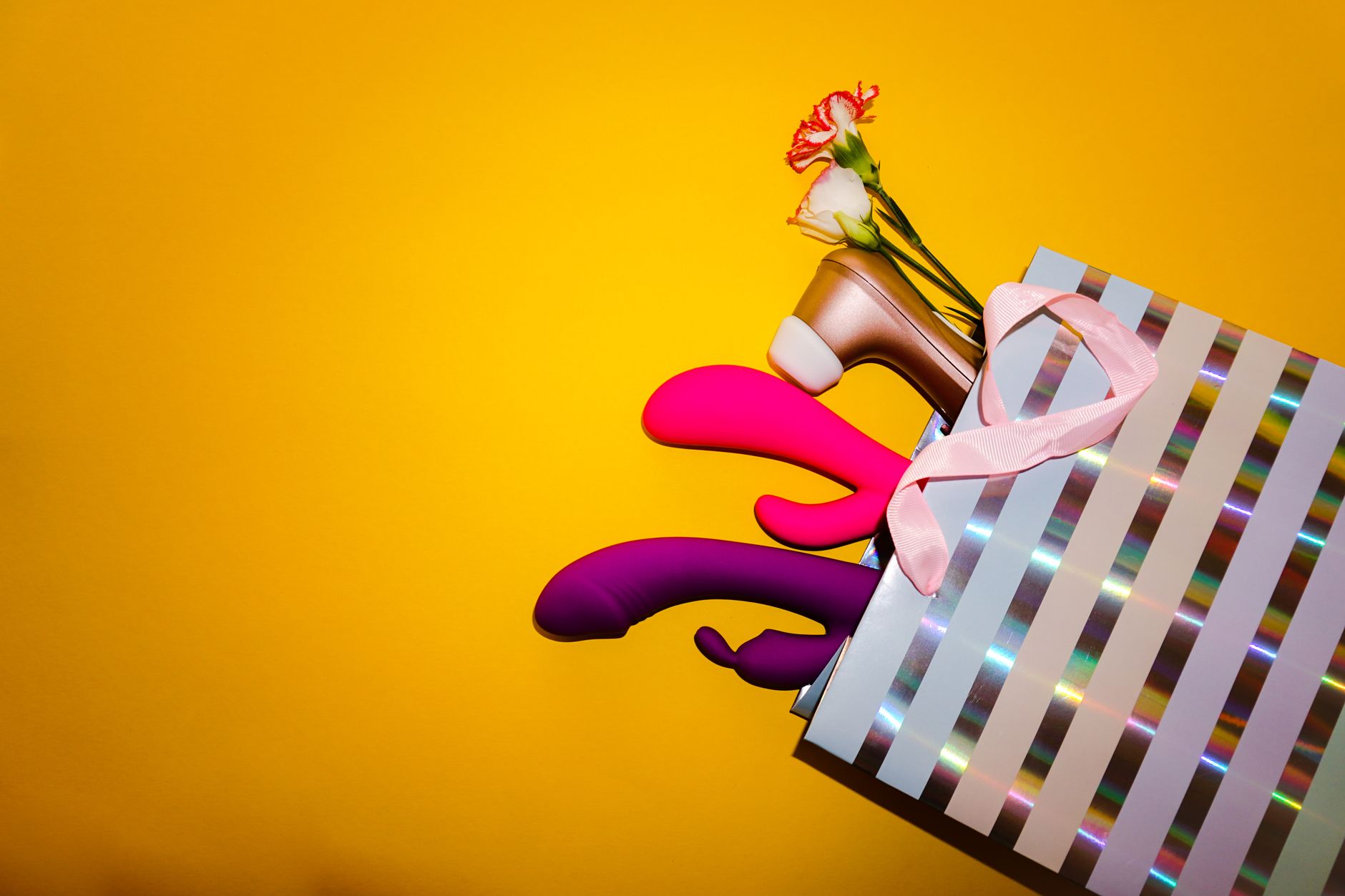 Woman holding colorful vibrators in a contemplative manner, representing openness to exploring pleasure together