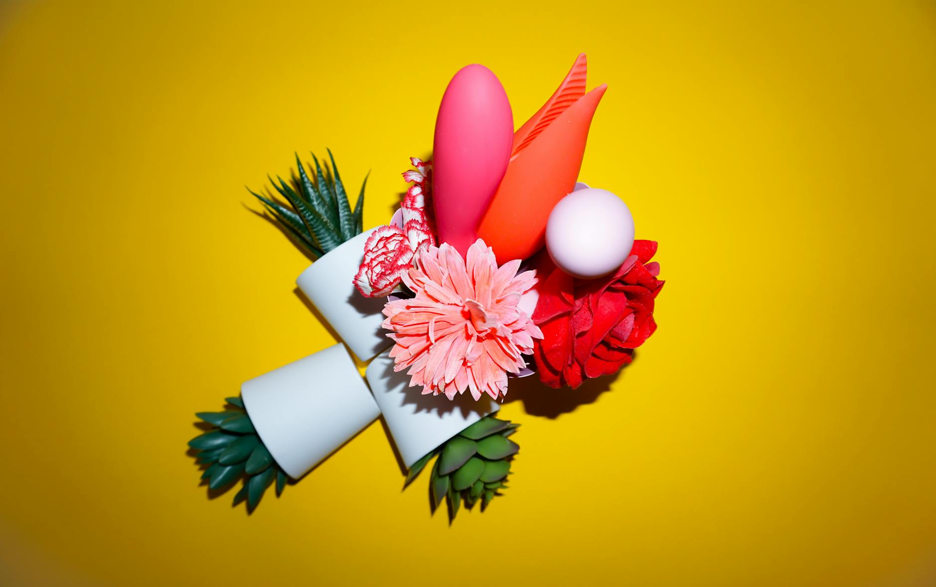 A hand holding an orange vibrator against a minimalistic purple backdrop, showcasing intimate self-care