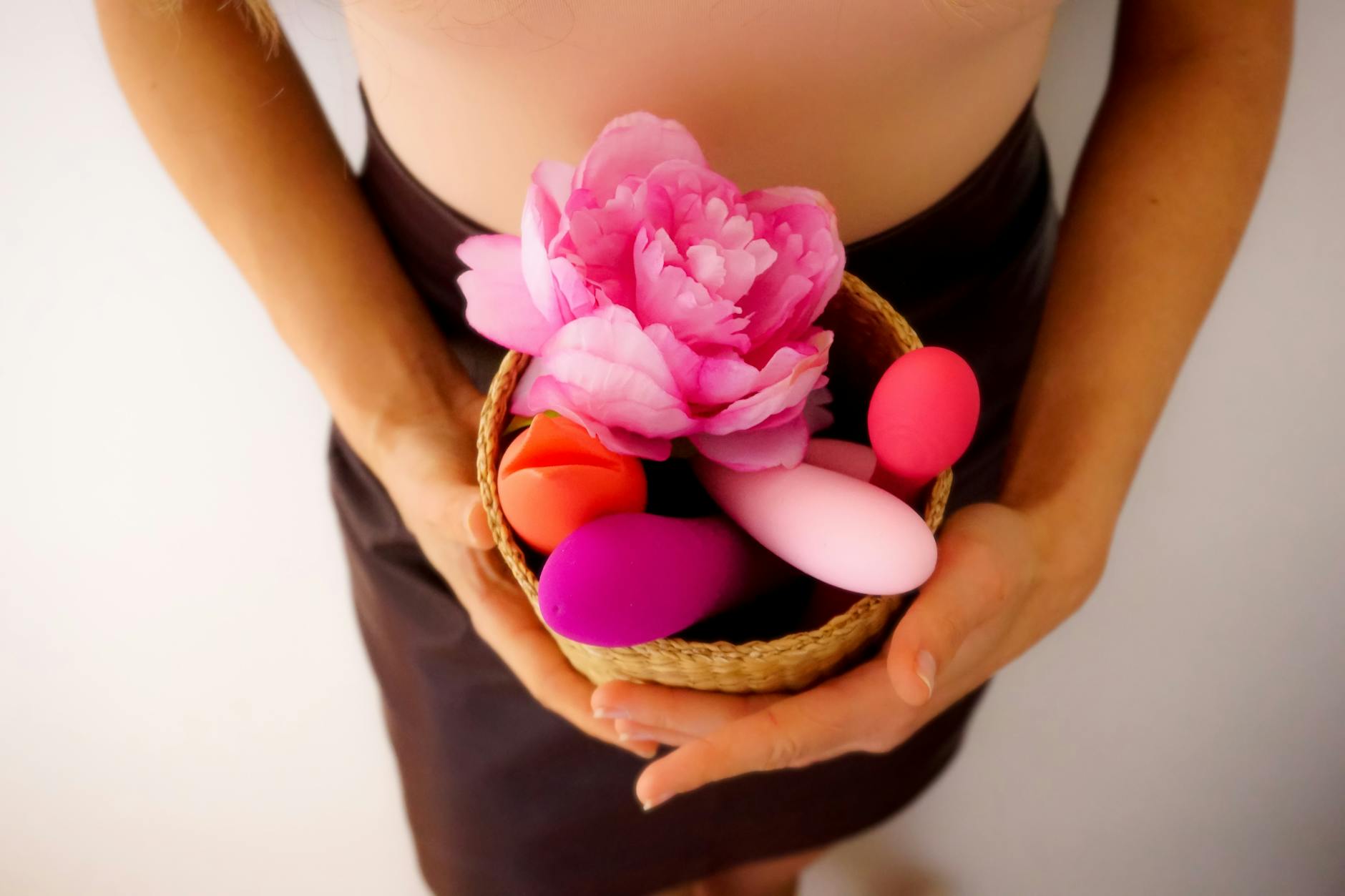 Blue vibrator surrounded by flowers and citrus slices on a bright yellow background