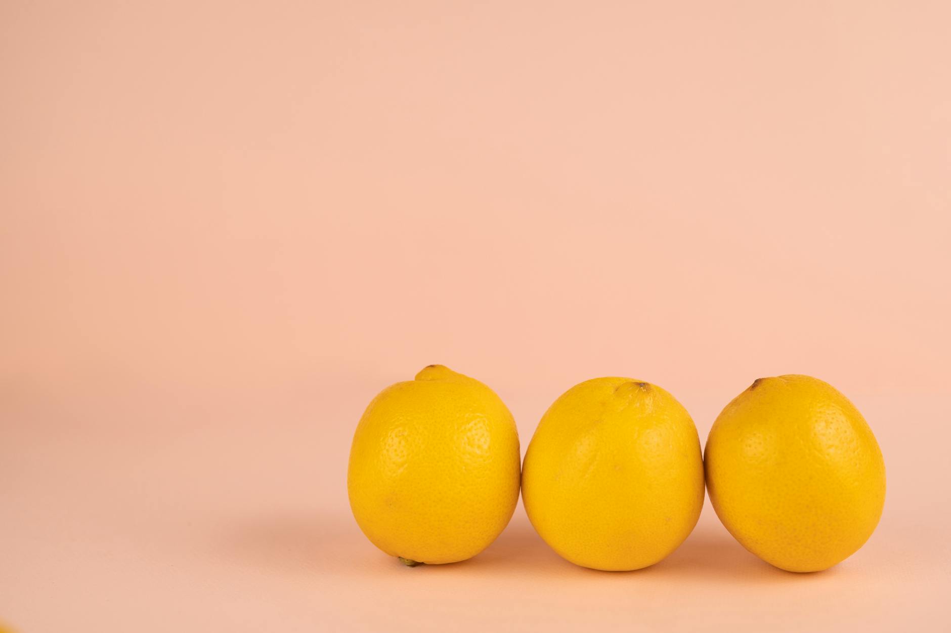 Close-up of hand holding an orange vibrator against a minimalistic purple backdrop, representing personal agency and sensuality